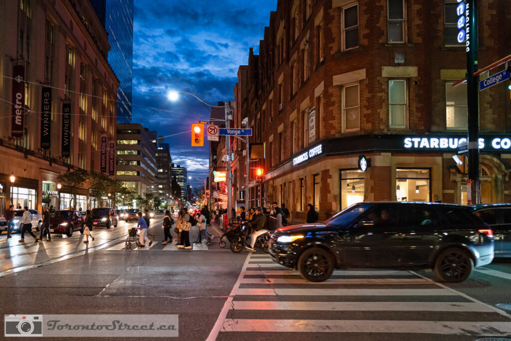 Yonge Street at dusk with moon rising, om a popular Starbucks corner Leica Q2