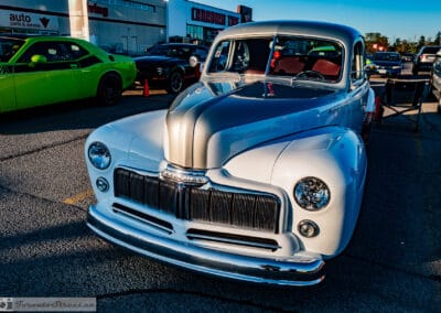 1948 Mercury Eight from the front quarter, brushed silver hood over white body, red interior glowing, Leica Q3
