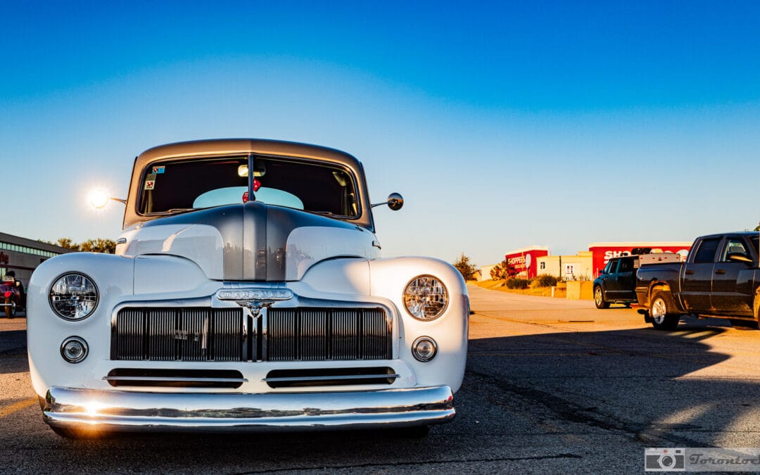 1948 Mercury Eight restomod head-on, chrome vertical-bar grille and twin headlights under a deep blue sky, Leica Q3