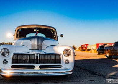 1948 Mercury Eight restomod head-on, chrome vertical-bar grille and twin headlights under a deep blue sky, Leica Q3