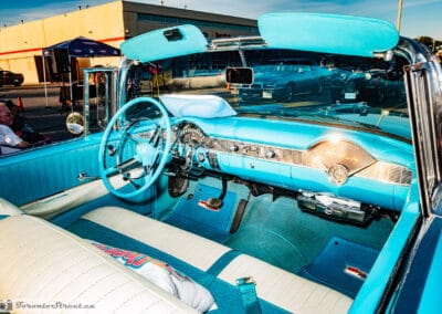 Turquoise dash and white seats inside a 1956 Bel Air convertible, a 56 Dream cushion on the seat, Leica Q3