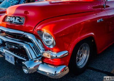 The orange truck parked in a row of cruise-night cars at dusk, Leica Q3