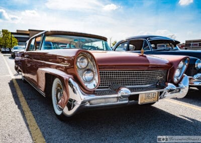 1958 Lincoln Continental Mark III in copper, canted quad headlights and a wide chrome grille under a blue sky, Leica Q3