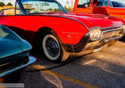Low front three-quarter of the red 1961 Thunderbird on its wire wheels in the lot, Leica Q3