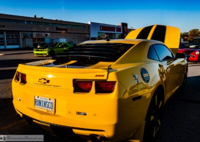 Yellow Camaro rear with the RS badge, dark taillights and a RUNINSCD Ontario plate, Leica Q3