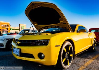 Front three-quarter of the Bumblebee-striped yellow coupe, HID halo headlights and twenty inch wheels, Leica Q3