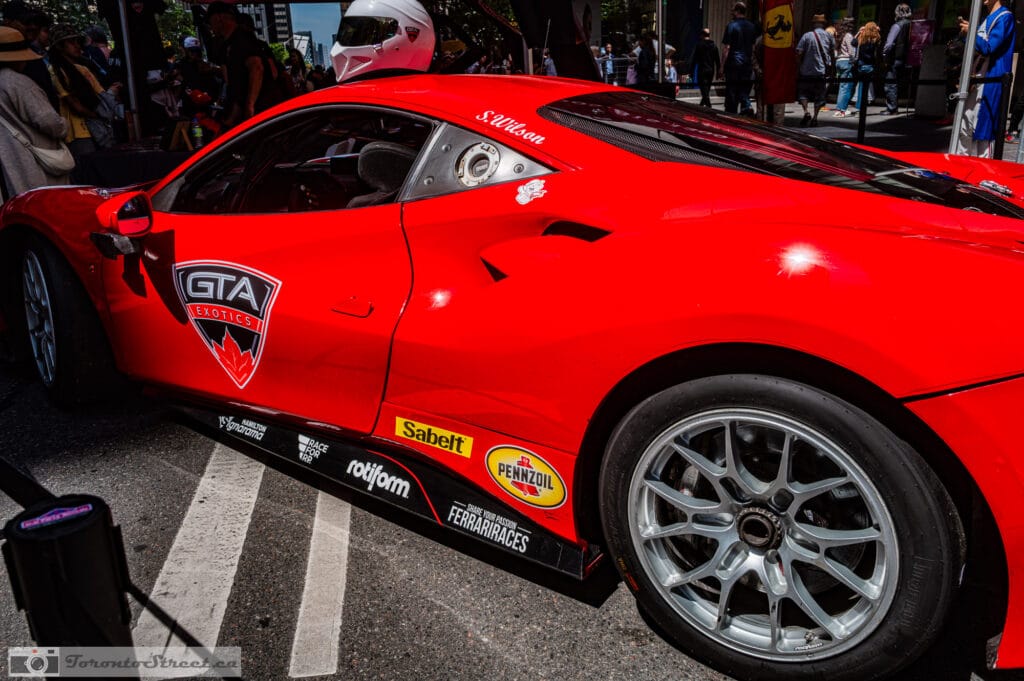 Ferrari 488 Challenge Evo,_-1000874 Red race car with GTA Exotics maple-leaf decals and driver name S. Wilson, spectators behind, Leica Q3