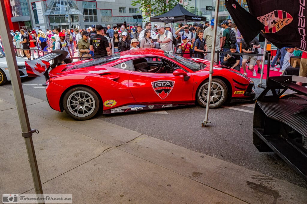 Ferrari 488 Challenge Evo,_-1000980 Scarlet race car between event tents near the Manulife Centre, Toronto exotic car show crowd, Leica Q3