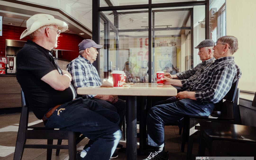 Four older men in caps and a cowboy hat around a Tim Hortons corner table, tim hortons street photography, Leica Q3