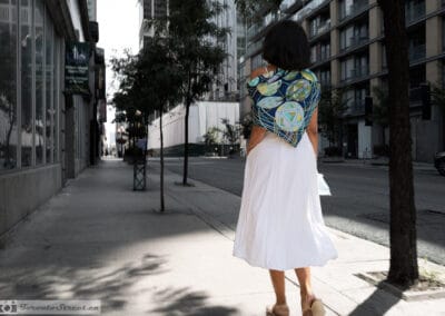 Woman in a flowing white skirt walking a quiet downtown street, shot from behind, toronto street photography interesting people, Leica Q2