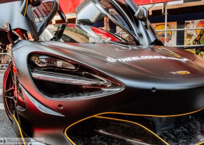 Eye-socket LED headlight and gold-lined intake on a matte black supercar, Leica Q3