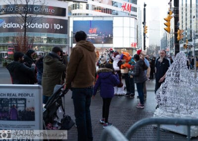 Costumed characters drawing a holiday crowd at Yonge-Dundas Square, wide scene, Leica Q2