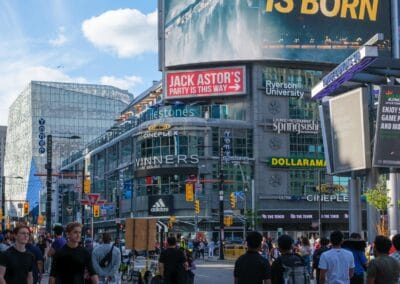 A New Legend Is Born billboard towering over Yonge-Dundas Square, a small weekend crowd below, Fuji X100V