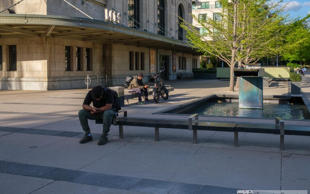 Man at the Summerhill LCBO fountain absorbed in his phone, a quiet Toronto Sunday afternoon, Fuji X100V