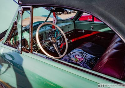 Ivory steering wheel, green dash and deep red leather seats through the side glass, Leica Q3