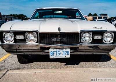 Head on view of the 442 grille badge and Ontario plate under a blue summer sky, Leica Q3
