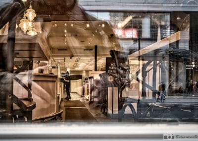 A Toronto cafe seen through layered glass, a physical distancing notice among the reflections, Leica Q2