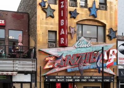 Club Zanzibar neon and gold facade on Yonge in the Six, a man on his phone in the doorway, Leica Q2