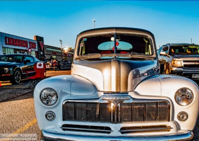 Wide head-on frame of the vertical-bar grille and split windshield, Canadian Tire sign behind, Richmond Hill, Leica Q3