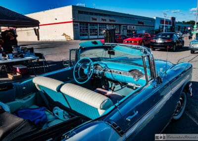 Looking down into a turquoise and white pleated interior, a tire shop across the lot, Leica Q3