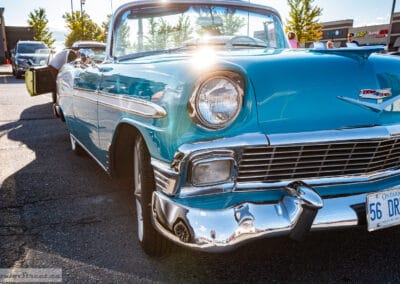 Low front three quarter, sun flaring off the windshield frame of a turquoise Chevrolet, Leica Q3