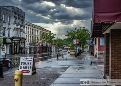 Sun breaking over a wet suburban main street of Victorian storefronts, Bowmanville, Fuji X-E2