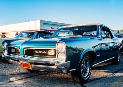 Turquoise Pontiac convertible on Rally wheels and Firestone tires parked outside the tire shop, Richmond Hill, Leica Q3
