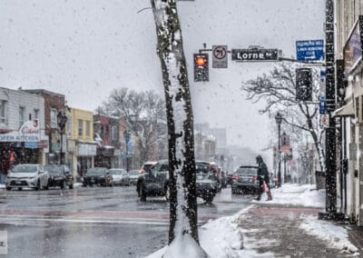 Snow falling on the main street through Richmond Hill, traffic and a shovelled sidewalk, Leica Q2
